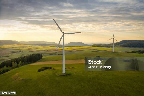 Alternative Energy Wind Turbine In Green Summer Landscape At Sunset Stock Photo - Download Image Now