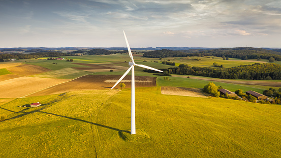 Wind Turbines in green rural landscape during sunset. Green Renewable Energy, Alternative Energy Environment Concept Shot.. Drone Point of View. Swabian Alb, Baden Württemberg, Germany, Europe