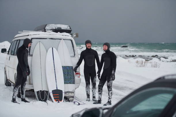 istock Arctic surfers in wetsuit after surfing by minivan 1293892007