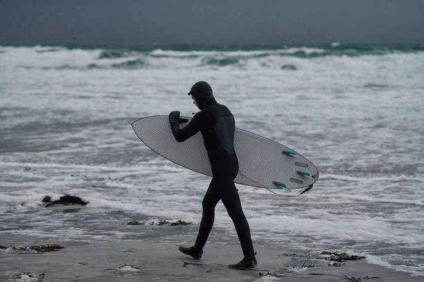 istock Arctic surfer going by beach after surfing 1293892775