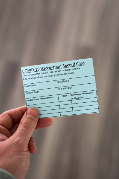 istock Hand holding covid-19 vaccination record card 1293894028