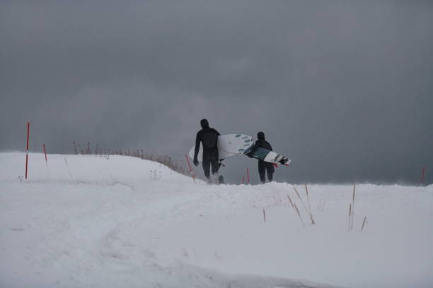 istock Arctic surfers running on beach after surfing 1293895049