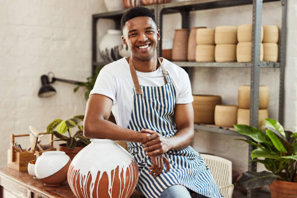 Hope you love our designs as much as we do Portrait of a confident young man working in a pottery studio pottery making stock pictures, royalty-free photos & images