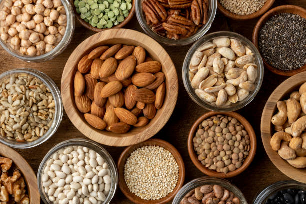 Healthy nuts, seeds and legumes (beans) Healthy nuts, seeds and legumes (beans) on a wood background. Vegan proteins. Bulk foods. legume family stock pictures, royalty-free photos & images