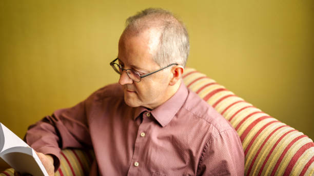 istock In full concentration a middle-aged man is sitting in sofa, reading an instruction manual 1293897789