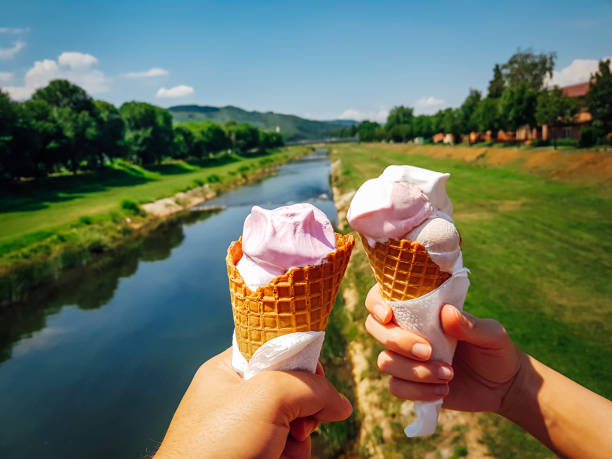 Couple on date holding tasty ice cream cones in their hands