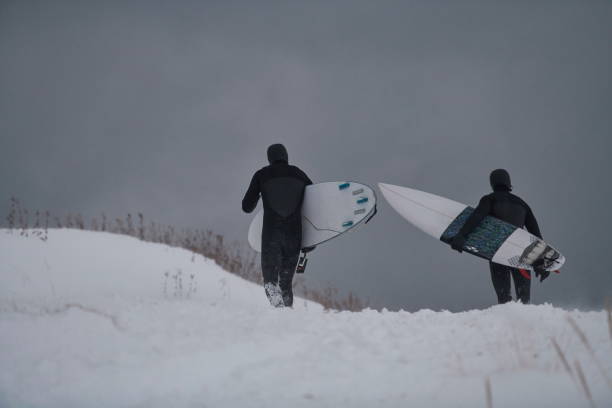 istock Arctic surfers running on beach after surfing 1293902416