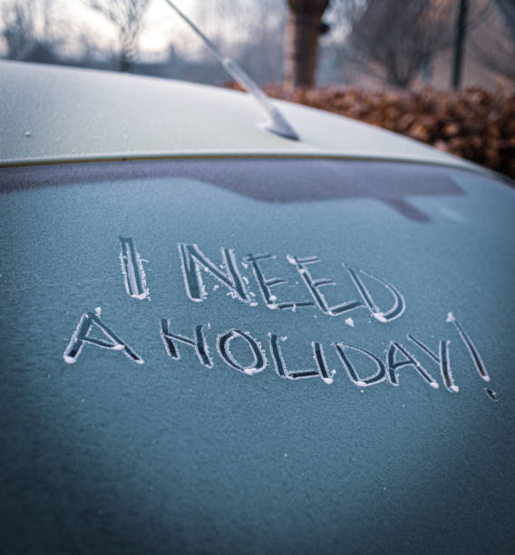 istock 'I NEED A HOLIDAY' handwritten on a frosty car windshield 1293902462