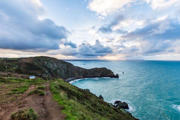 landschaft bei sonnenaufgang über dem nez de jobourg von den klippen am rande des kanals (normandie, frankreich) - cliff at the edge of grass sea stock-fotos und bilder