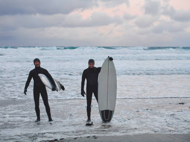 istock Arctic surfers going by beach after surfing 1293910150