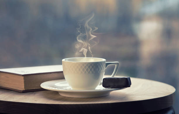 istock White coffee cup with smoke and brown book on table in cafe 1293910967