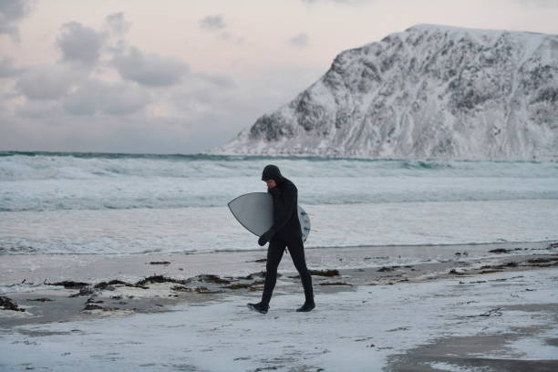 istock Arctic surfer going by beach after surfing 1293911583