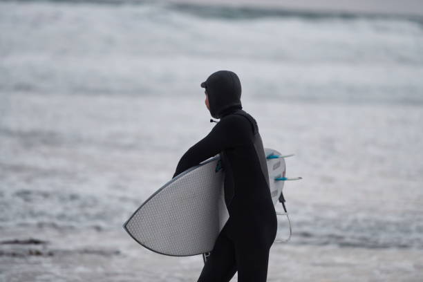 istock Arctic surfer going by beach after surfing 1293916870