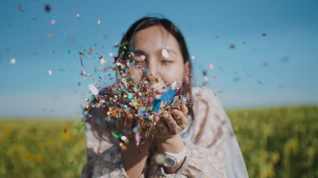 Slow motion woman blowing confetti