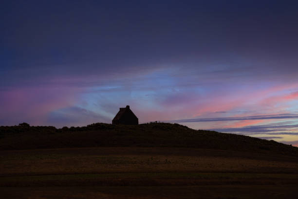 Small house on the horizon during a sunset in Guernsey