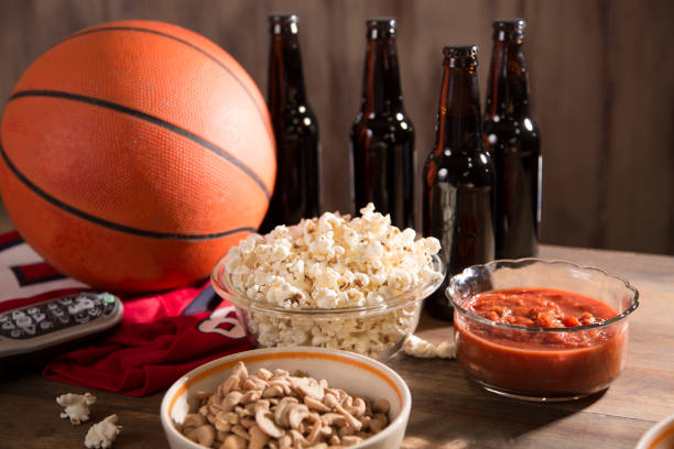 oglądanie gry w koszykówkę z przekąskami, napojami. - cashew beer nuts nut food zdjęcia i obrazy z banku zdjęć
