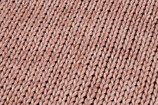 istock Knitted material from woolen threads of light beige color without ornaments 1293924801