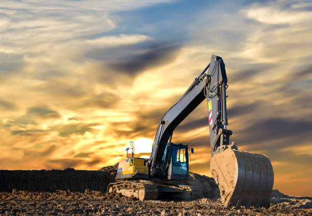 istock Excavator working on earthmoving at open pit mining on amazing sunset background 1293925597