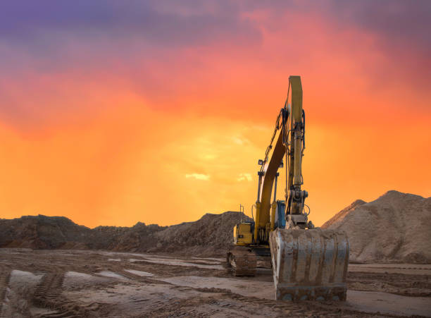 istock Excavator working on earthmoving at open pit mining on amazing sunset background 1293925608