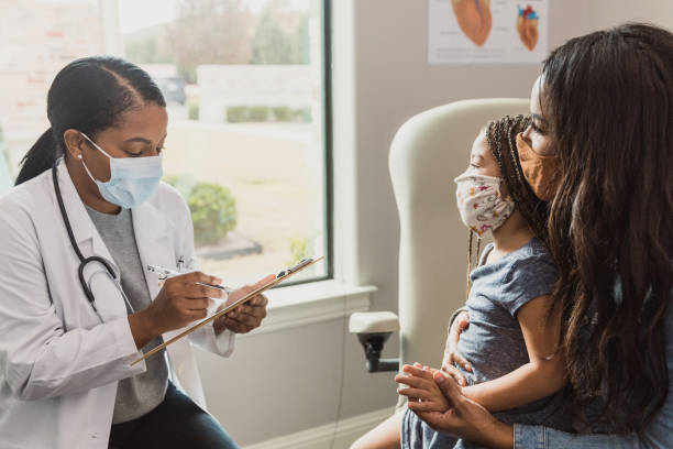 istock Mother and daughter answer doctor's questions 1293927051