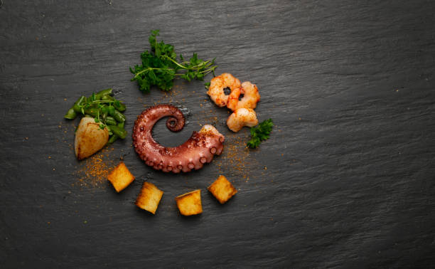 tentaculo de pulpo a la plancha sobre plato de piedra negra servido con camarones - fried onion roasted chopped fotografías e imágenes de stock
