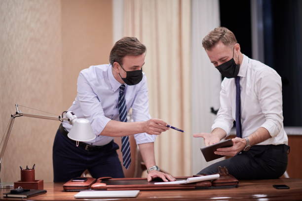 istock business people wearing crona virus protection face mask on meeting 1293934607