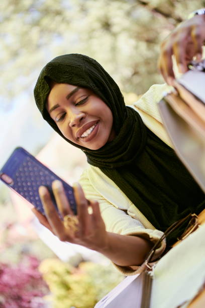 istock african woman using smartphone wearing traditional islamic clothes 1293935897