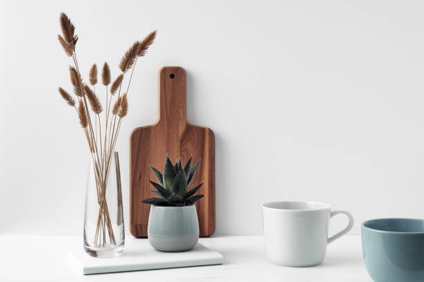 a mug, a potted houseplant, a clear vase and a wooden cutting board. eco-friendly materials in the decor of the room, minimalism. copy space, mock up - 13603 imagens e fotografias de stock