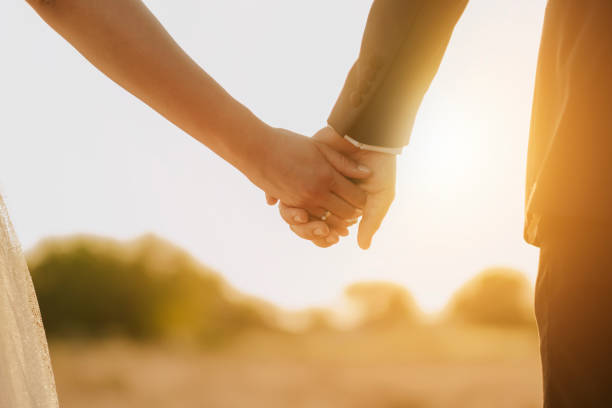 istock Couple holding hands in front of a sunset 1293941654