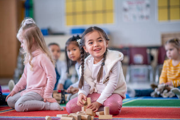 istock Young Caucasian girl smiling at camera in classroom 1293942527