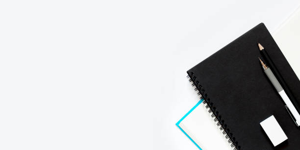 istock Black notebook with White pencil eraser black pencil for drawing on a white table, school concept with copy space, Top view, flat lay, workplace composition 1293948076