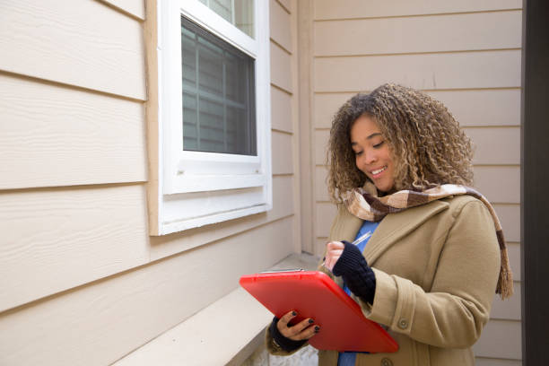lovely african american woman completes real estate appraisal for home sale. - quality control examining house residential structure imagens e fotografias de stock