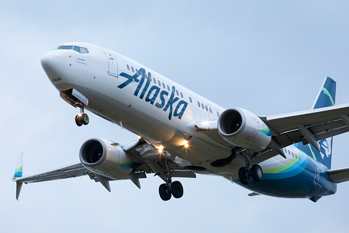 Portland, Oregon, USA - December 22, 2020: An Alaska Airlines Boeing 737 landing at Portland International Airport at dusk.