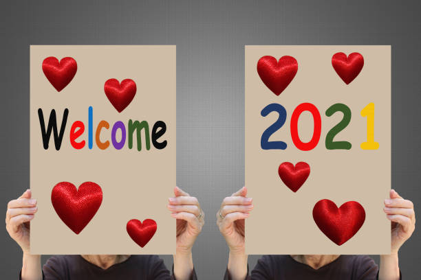 istock Welcome 2021 Signs held by two women 1293960040