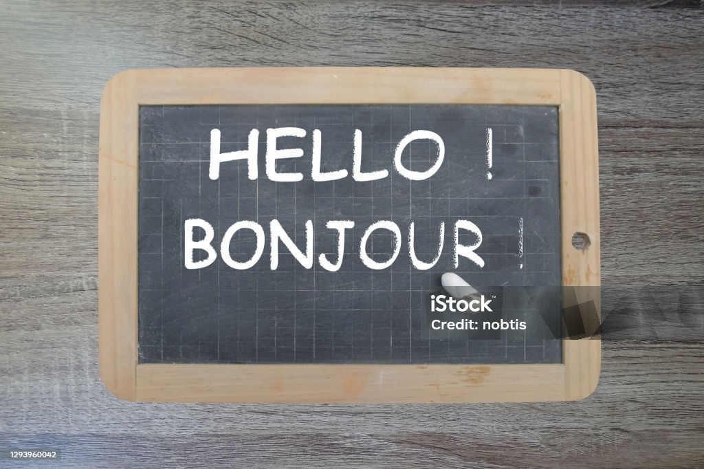 Hello ! Bonjour !  Message written on a slate with chalk Hello - Single Word Stock Photo