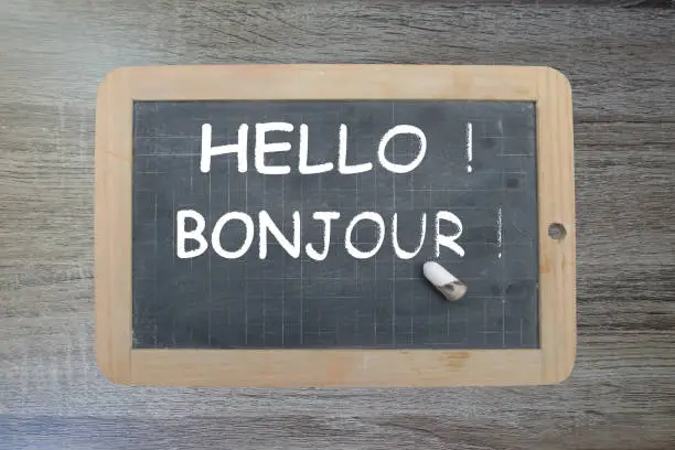 Hello ! Bonjour !  Message written on a slate with chalk