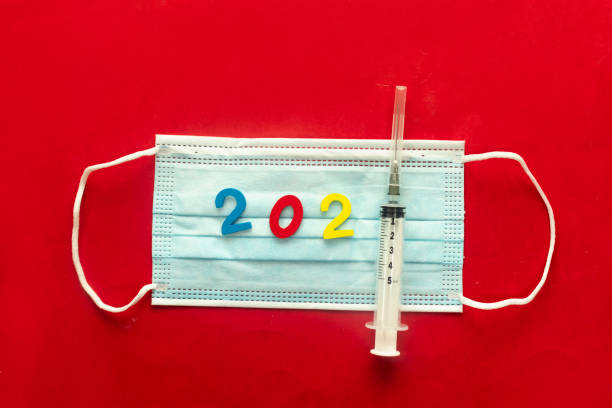 istock new year concept with covid 19 vaccine on red background 1293977438