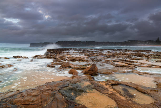istock Rock platform, cascades and splashes with rain clouds by the seaside 1293978010