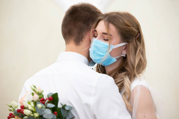 istock Bride and groom wearing medical masks. 1293986128