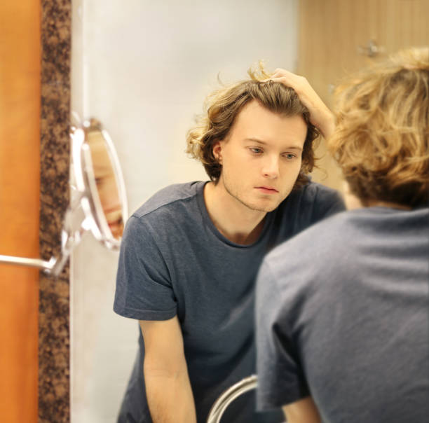 istock Applying the cream.young man looking in the mirror 1293991281