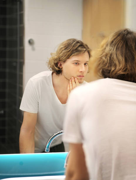 istock Applying the cream.young man looking in the mirror 1293991282