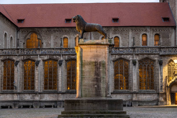 Bronze lion statue on a high pedestal in old town of Braunschweig Braunschweig, Germany - dec 31th 2020: Lion is a symbol animal of historical town Braunschweig. It's used as a theme in different statues around the city. braunschweig stock pictures, royalty-free photos & images