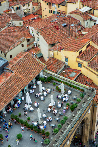 os clientes de um café ao ar livre, o loggia dei lanzi, visto do palazzo vecchio, desfrutam da paisagem de florença cercada por telhados de terracota em um dia de verão. - palazzo vecchio piazza della signoria florence italy italy - fotografias e filmes do acervo