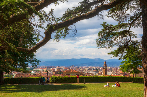 Florence, Italy - June 18, 2014: Tourist explore the grounds of the Boboli Gardens, with the cityscape providing a beautiful background during a summer day.