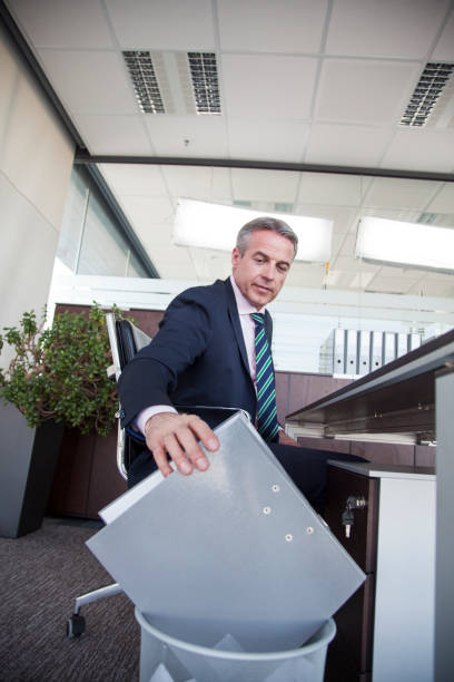 istock Businessman puting file in a garbage basket 1293999338