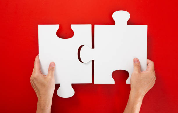 istock Concept of business,hand solving a puzzle piece on red background. 1294002091