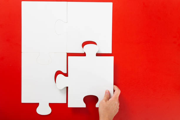 istock Concept of business,hand solving a puzzle piece on red background. 1294002136