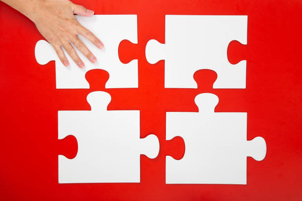 istock Concept of business,hand solving a puzzle piece on red background. 1294002187