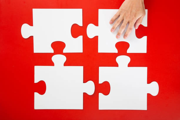 istock Concept of business,hand solving a puzzle piece on red background. 1294002193