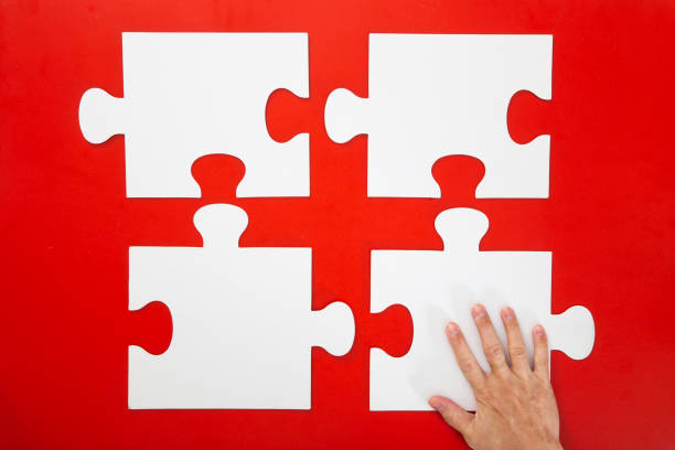 istock Concept of business,hand solving a puzzle piece on red background. 1294002206